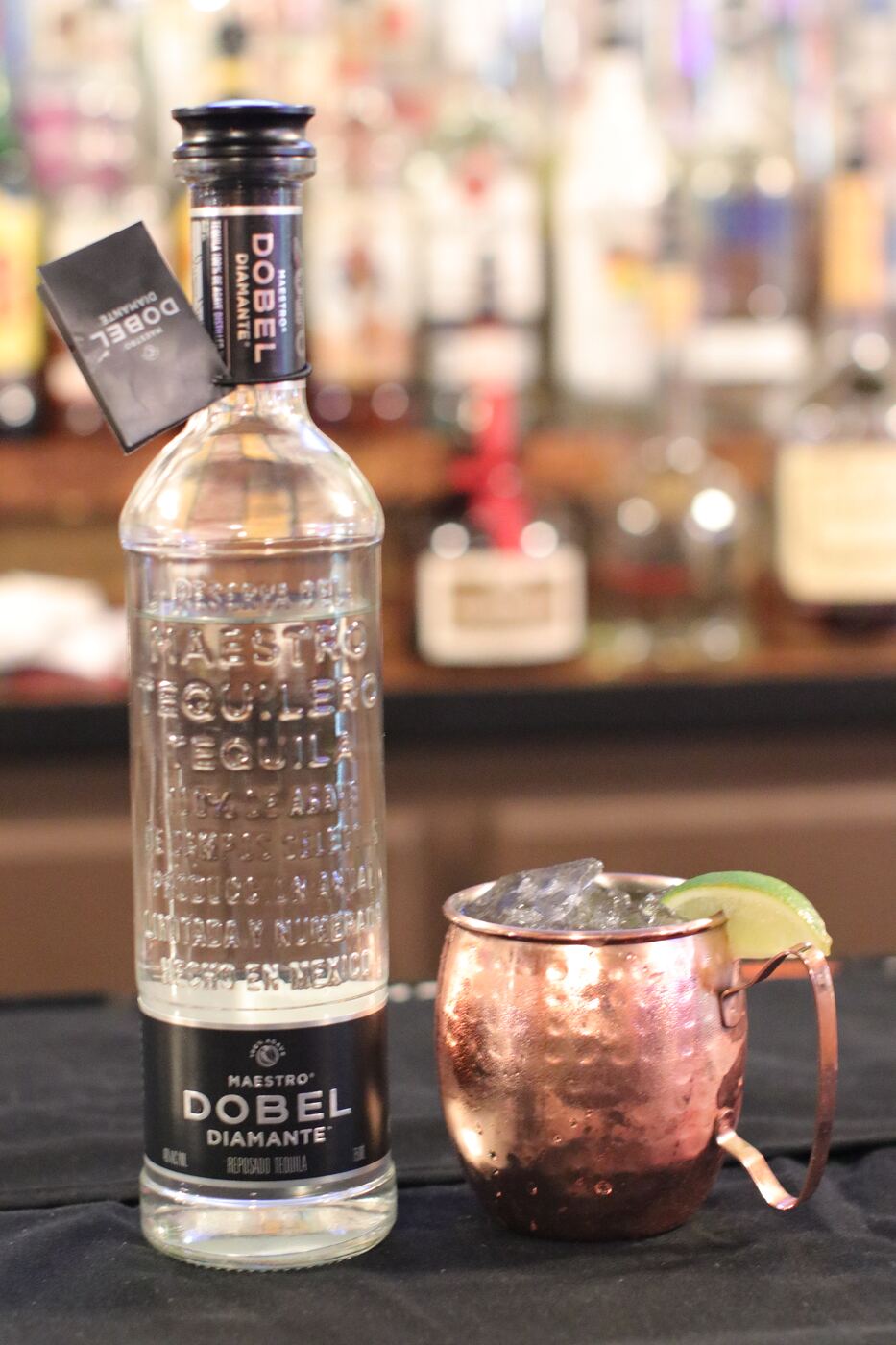 Mule in a copper mug next to a bottle of Dobel tequila